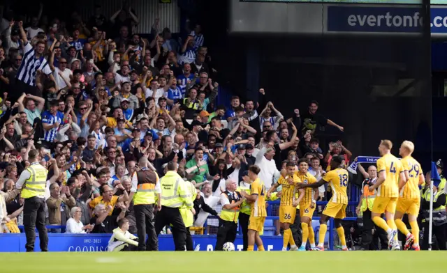 Brighton players celebrate in the corner with the away fans