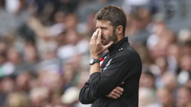 Michael Carrick covers his face with his hand on the touchline