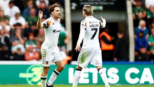 Lewie Coyle claps hands with a team-mate after scoring