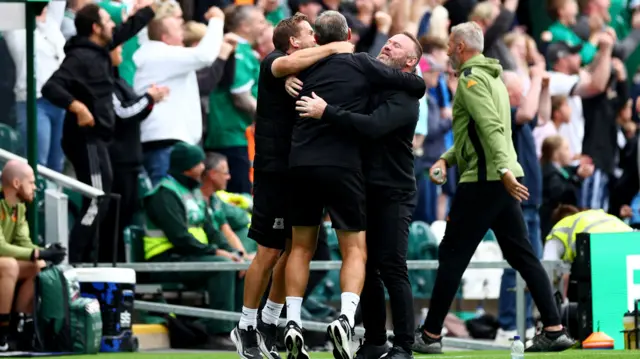 Wayne Rooney hugs his coaching staff in celebration