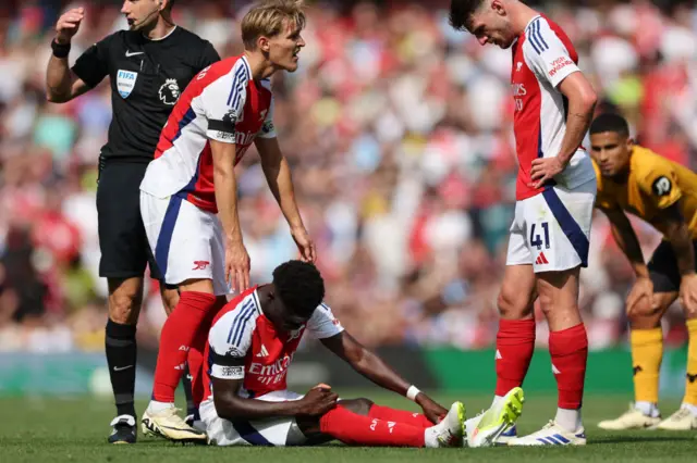 Saka sits on the floor after hurting himself