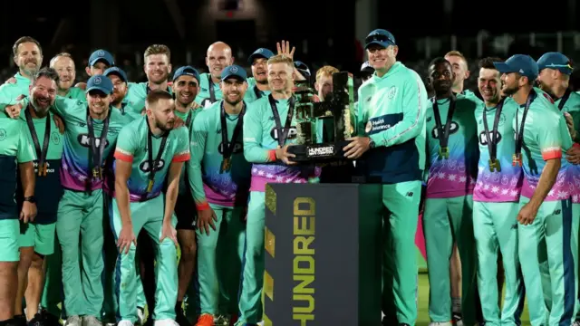 Sam Billings and Andrew McDonald, Head Coach of Oval Invincibles, pose for a photo with teammates and The Hundred Men's Champions Trophy after Oval Invincibles defeat Manchester Originals during The Hundred Final between Oval Invincibles Men and Manchester Originals Men at Lord's Cricket Ground on August 27, 2023