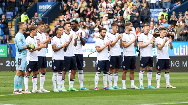 Bolton players take part in a minute's applause before the start of the match