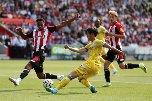 Daichi Kamada of Crystal Palace crosses the ball under pressure from Ethan Pinnock