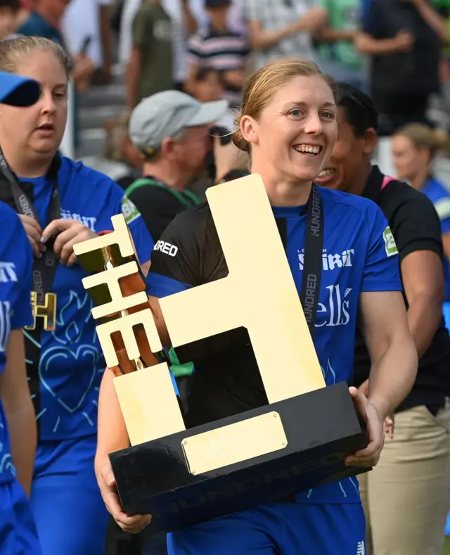 Heather Knight clutches the giant Hundred trophy