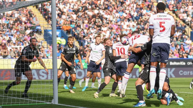 Eoin Toal of Bolton Wanderers has his header cleared off the line by Max Cleworth of Wrexham