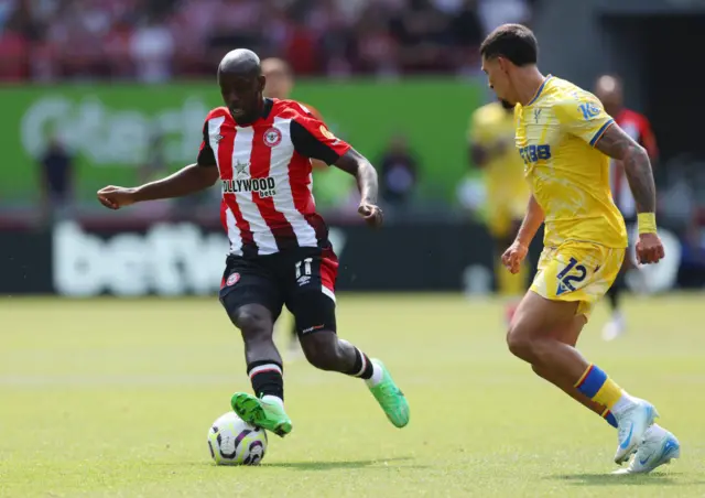 Yoane Wissa of Brentford runs with the ball under pressure from Daniel Munoz of Crystal Palace