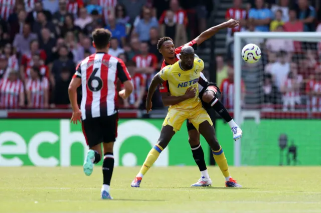 Jean-Phillippe Mateta of Crystal Palace is challenged by Ethan Pinnock of Brentford