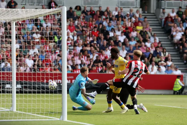 Mark Flekken of Brentford fails to save a shot after it was deflected by Ethan Pinnock of Brentford