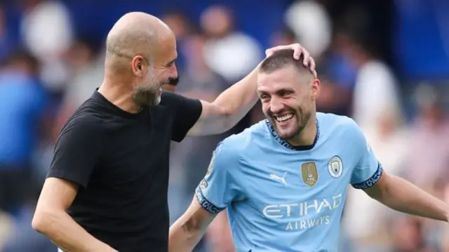 Manchester City manager Pep Guardiola celebrates with midfielder Mateo Kovacic