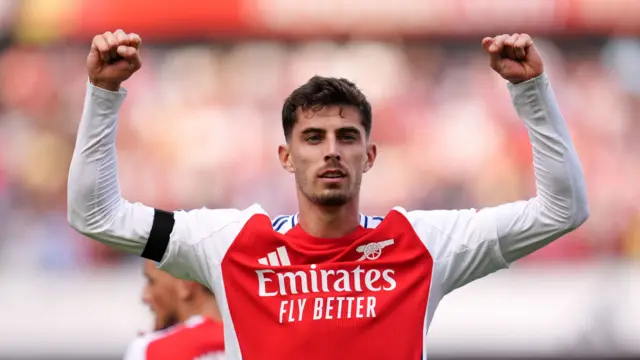 Kai Havertz faces the Arsenal fans with his arms aloft in celebration