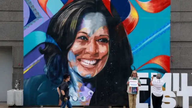 People take a photo in front of a mural of Democratic presidential candidate U.S. Vice President Kamala Harris hanging outside of the United Center, site of the Democratic National Convention on August 17, 2024 in Chicago, Illinois.