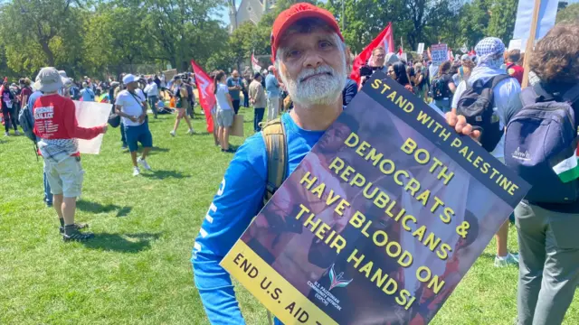 Tallis George Munro holding a protest sign