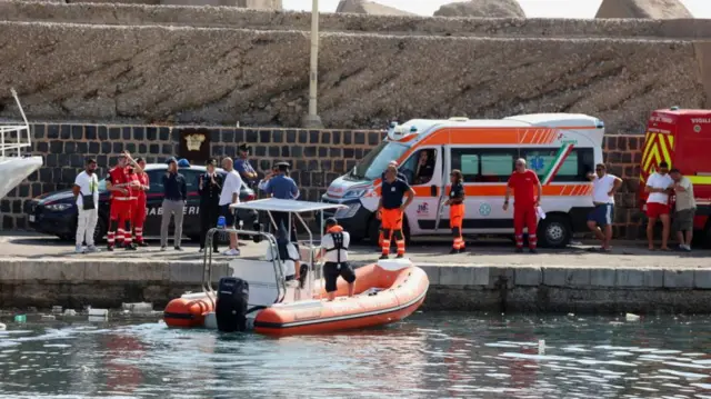 Emergency and rescue services work near the scene where a sailboat sank in the early hours of Monday, off the coast of Porticello, near the Sicilian city of Palermo, Italy