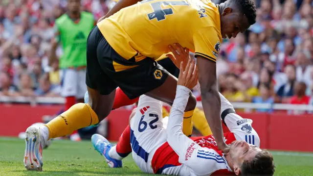 Wolves' Yerson Mosquera leans on Arsenal's Kai Havertz as he lies on the field