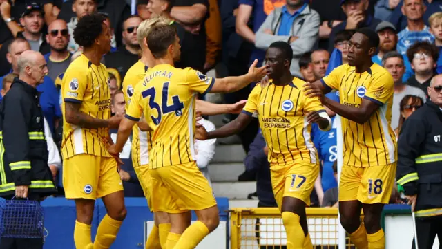 Brighton players celebrate scoring a goal at Everton