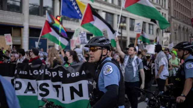 Police officers stand near marching activists as they wave Palestinian flags ahead of the Democratic National Convention (DNC), in Chicago, Illinois, U.S., August 18, 2024.