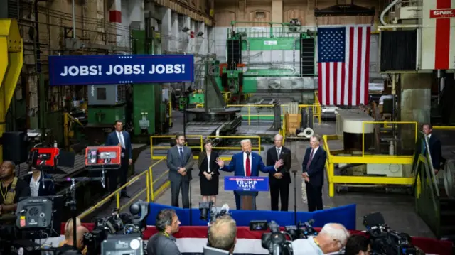 Former US President Donald Trump, center, speaks during a campaign event at Precision Components Group in York, Pennsylvania, US, on Monday, Aug. 19, 2024. The race for the White House will reach a fever pitch this week, with Vice President Kamala Harris and Republican nominee Donald Trump battling for momentum, and attention, around the Democratic National Convention in Chicago. Photographer: Graeme Sloan/Bloomberg via Getty Images