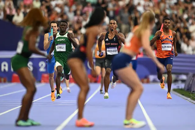 Britain's Alex Haydock-Wilson (C) runs with the baton