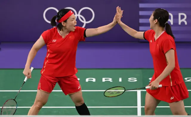 China's Chen Qing Chen and Jia Yi Fan celebrate winning a point in the women's doubles badminton semi-final match against Malaysia