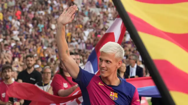 Dani Olmo waves as he is presented to the Barcelona fans