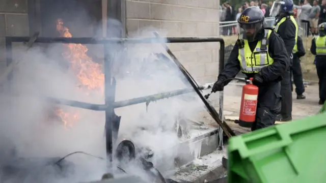 Police extinguish a fire at a hotel in Rotherham on 4 August