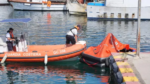 An emergency service worker setting up an inflatable life raft