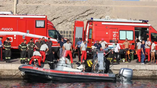 Rescue workers and divers from the Italian fire brigade as a rescue operation continues for the missing people who were on board a sailboat that sank, in Porticello, Sicily Island