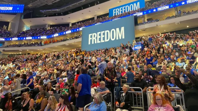 Crowd in an arena and a large sign that says Freedom