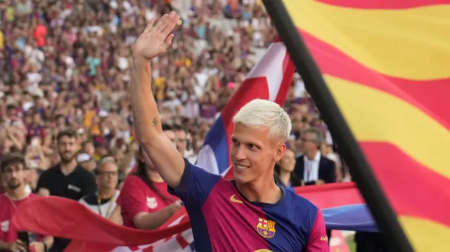 Dani Olmo waves as he is presented to the Barcelona fans