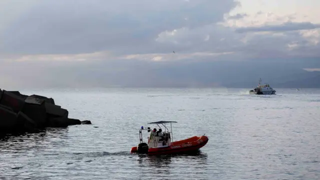 Rescue boats operate on the sea to search for the missing