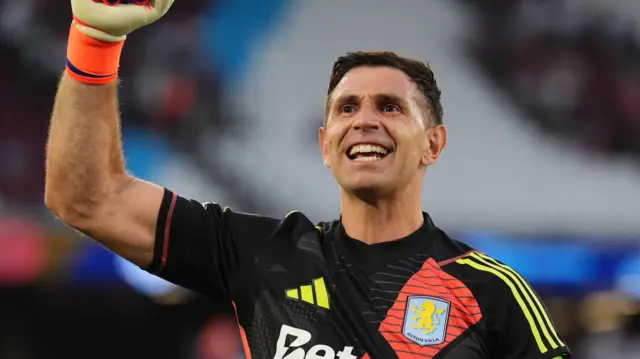 Emiliano Martinez salutes the Aston Villa fans in celebration