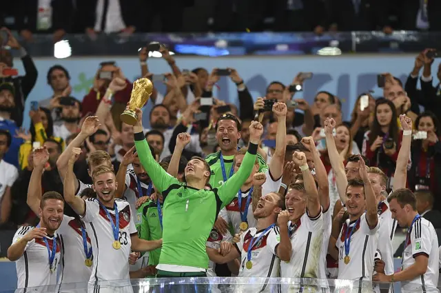 Manuel Neuer (front C) and team-mates celebrate with the World Cup trophy