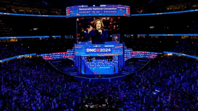 An enormous screen shows Harris speaking to the DNC crowd