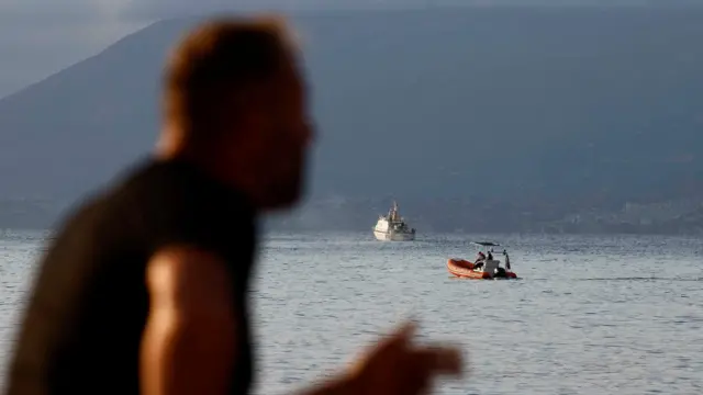 Rescue boats operate on the sea to search for the missing