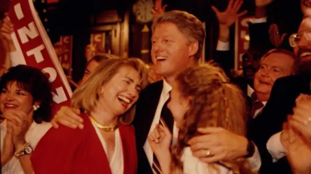 Bill Clinton with his arms around Hillary Clinton and daughter, Chelsea Clinton