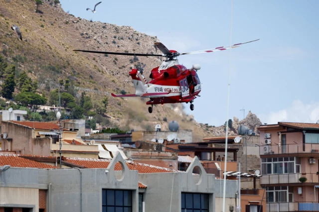 A fire brigade helicopter lands near the port