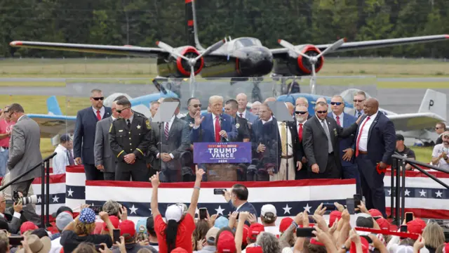 Trump and his entourage stand on stage