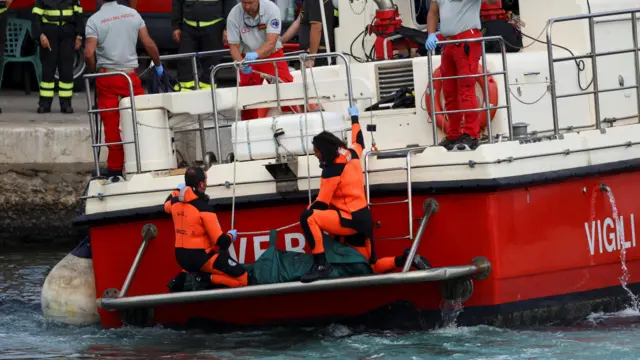 Rescue personnel transport a body bag