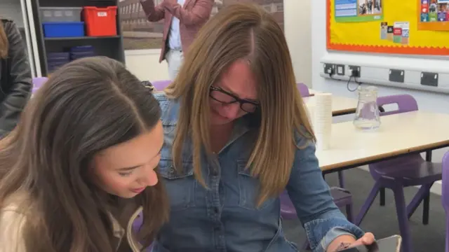 A woman and her daughter looking at GCSE results