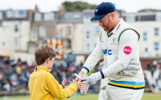 Jonny Bairstow signs an autograph for a young fan