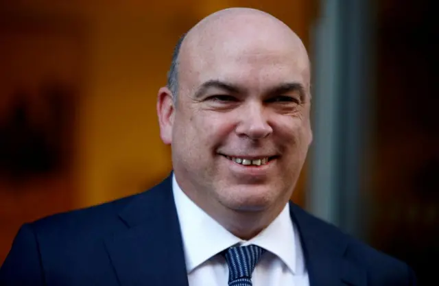 Headshot of Mike Lynch wearing a suit and smiling