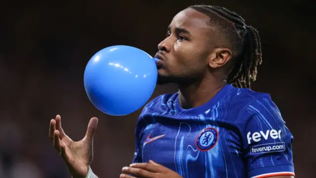 Christopher Nkunku blows a balloon