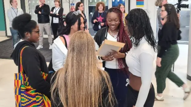 A group of students opening exam results