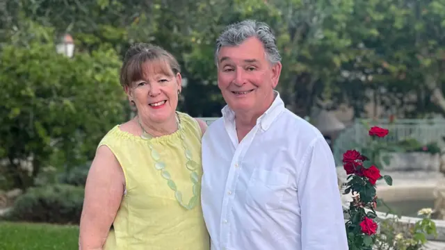 Jonathan and Judy Bloomer stand with their arms round each other