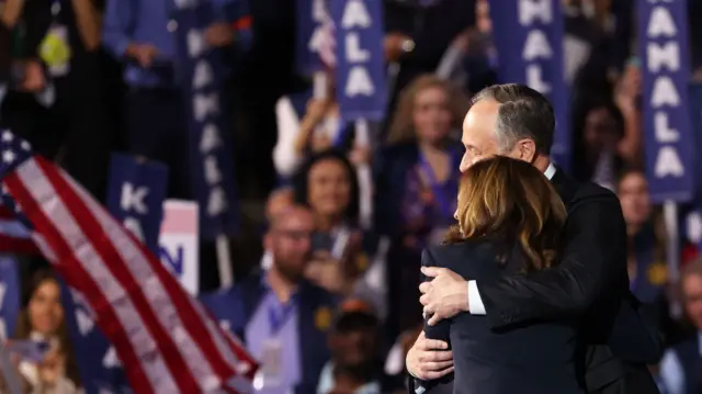 Democratic presidential nominee and Vice President Kamala Harris embraces her husband, second gentleman Doug Emhoff, after delivering her speech where she accepted the nomination for president