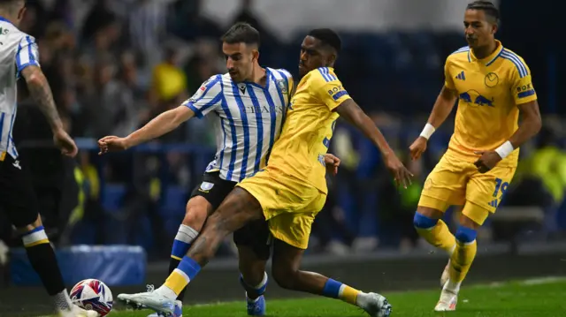 Pol Valentín of Sheffield Wednesday is tackled by Júnior Firpo of Leeds United