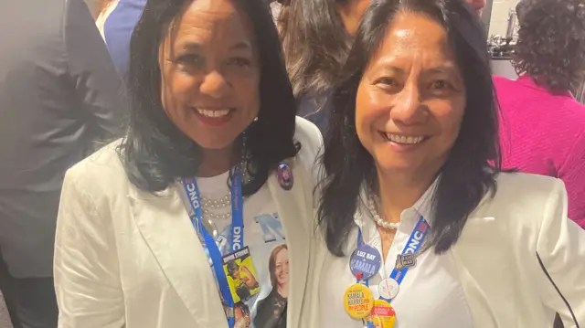 Two women wearing white suits