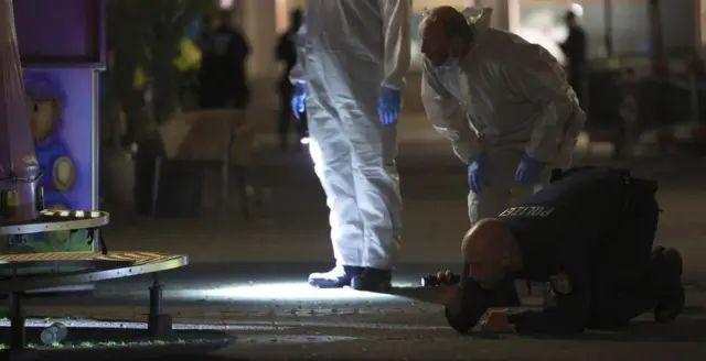 Investigators search under a vehicle