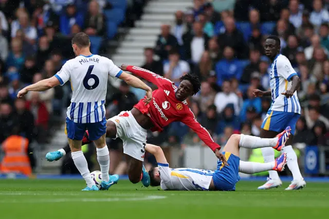 Kobbie Mainoo of Manchester United is challenged by Billy Gilmour